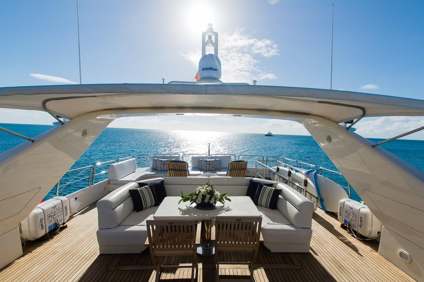 a deck with a table and chairs on it and a ship in the background aboard NO NAME AZIMUT 100 JUMBO Yacht for Sale
