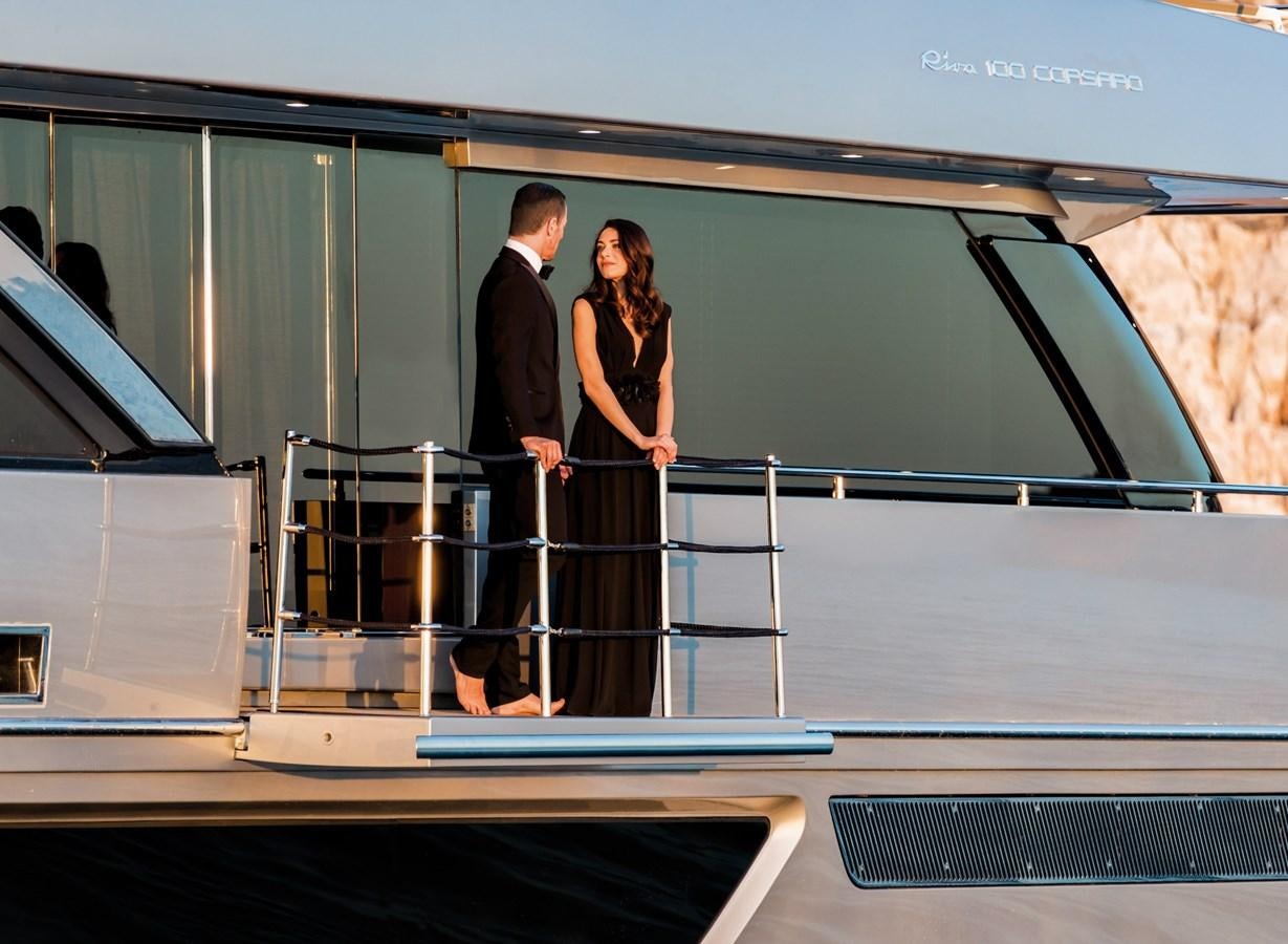 a man and woman standing on a balcony aboard BESO Yacht for Sale