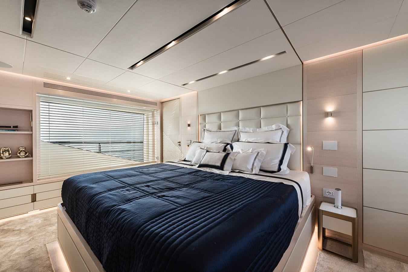 a bedroom with a bed and a window aboard TABOO OF THE SEAS Yacht for Sale