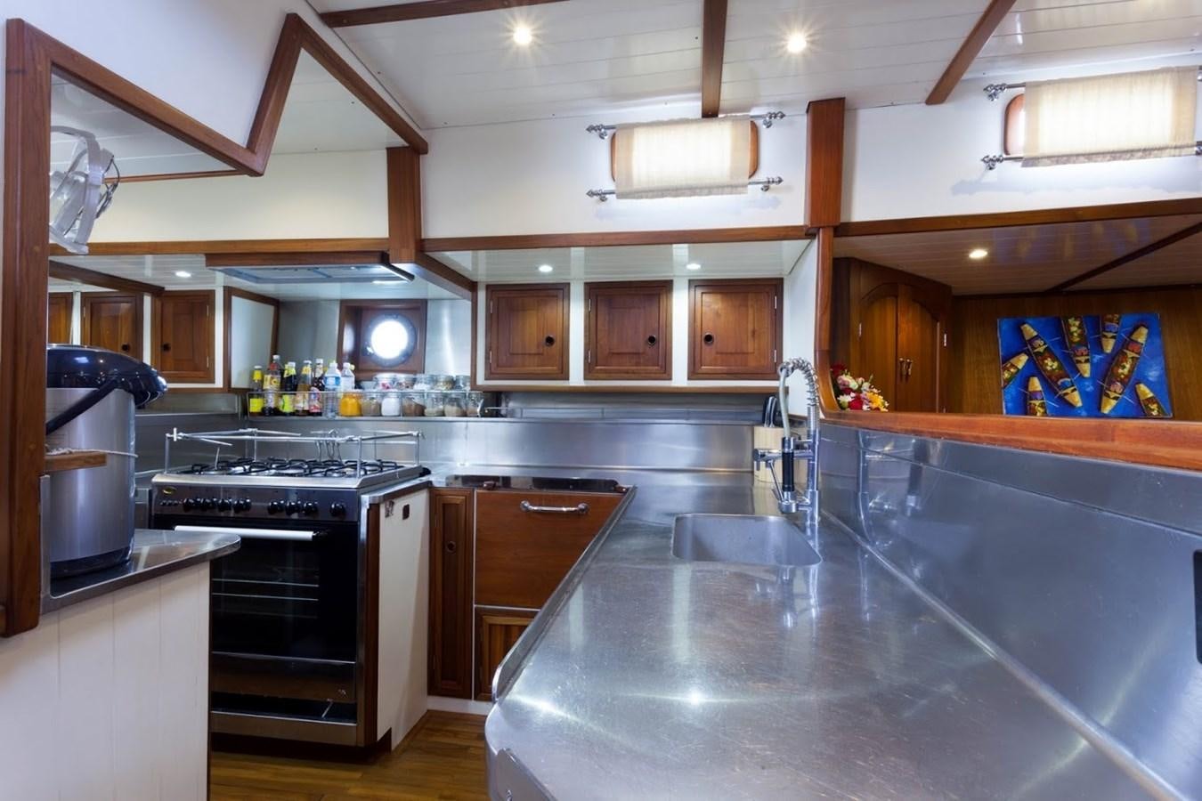a kitchen with wooden cabinets aboard DALLINGHOO Yacht for Sale