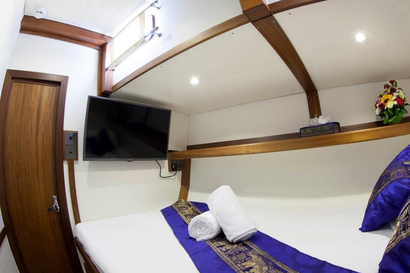 a room with a bed and a television aboard DALLINGHOO Yacht for Sale
