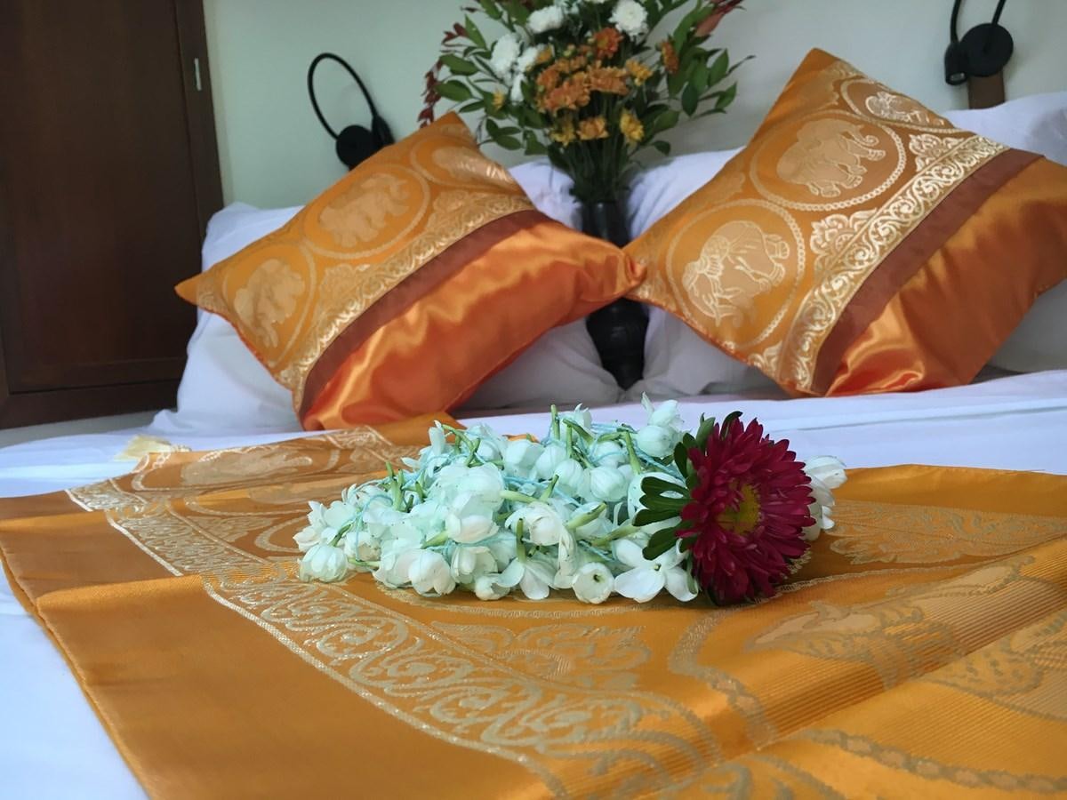 a bed with a flower and pillows aboard DALLINGHOO Yacht for Sale