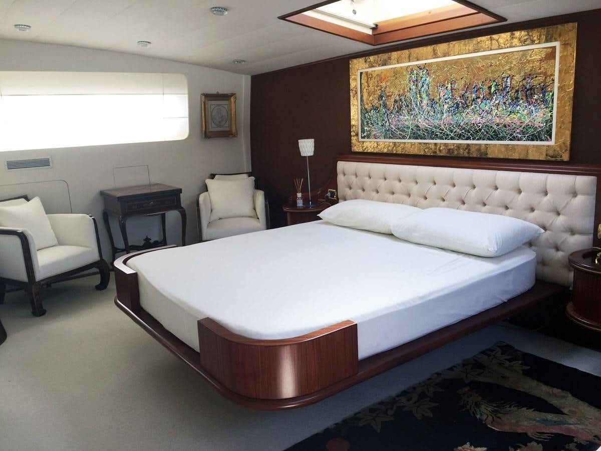 a bed with a chair and a table in a room aboard GIAVA Yacht for Sale