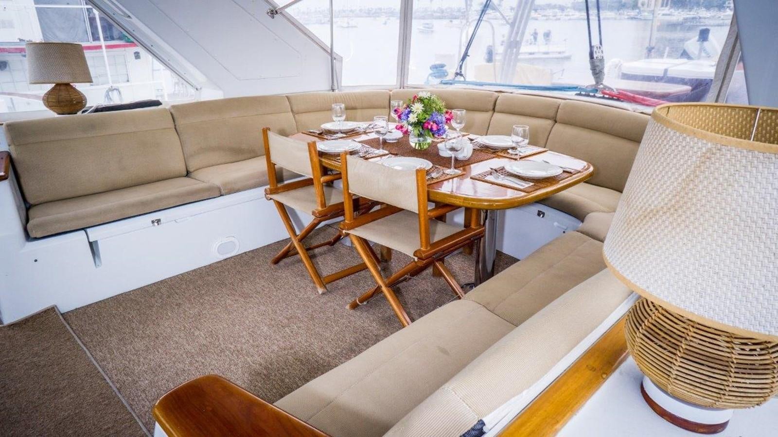 a table with chairs and a couch aboard ODYSSEUS Yacht for Sale