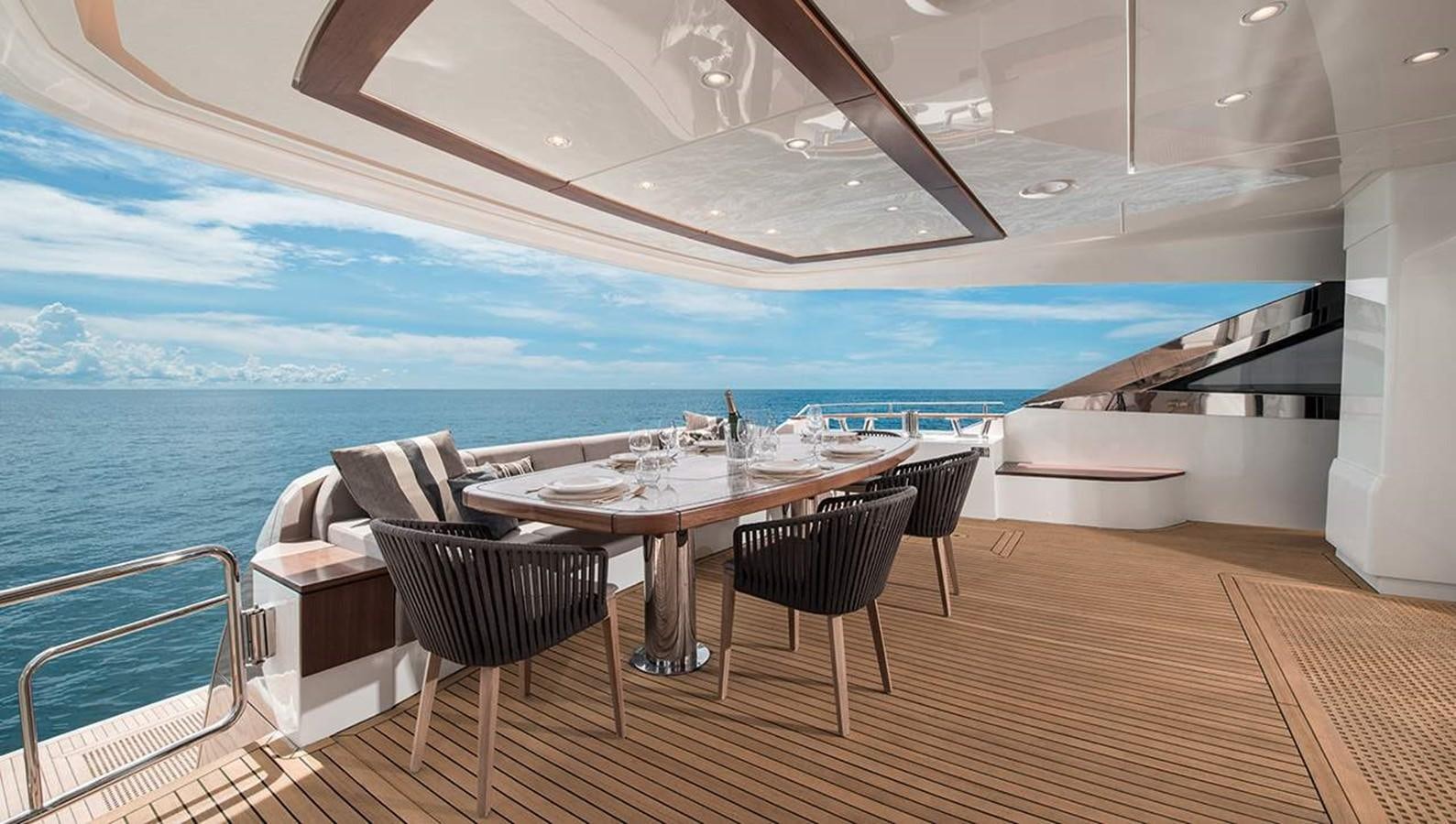 a table and chairs on a deck aboard MONTE CARLO YACHTS MCY 96 Yacht for Sale