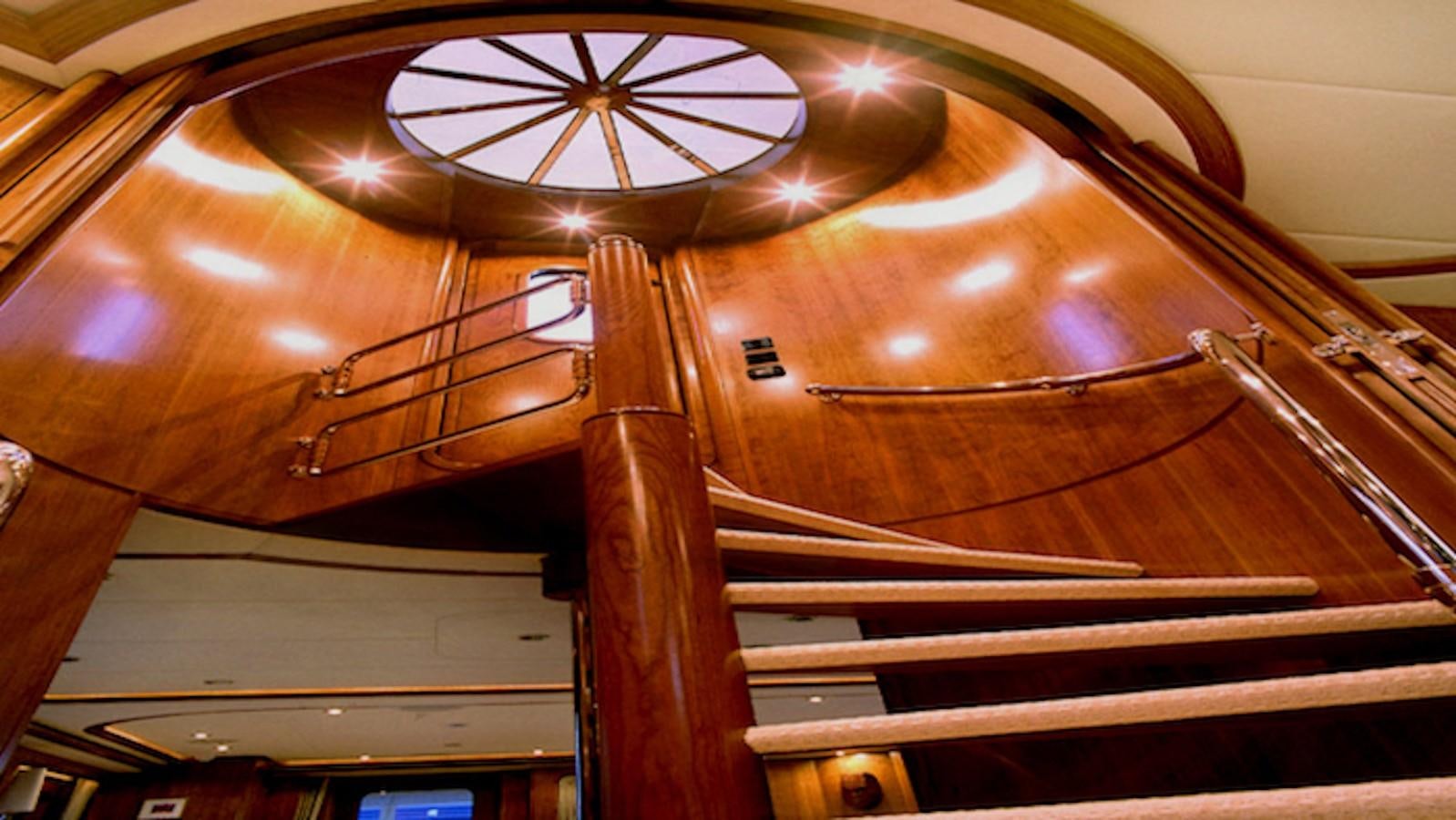a wooden spiral staircase aboard MAVERICK Yacht for Sale