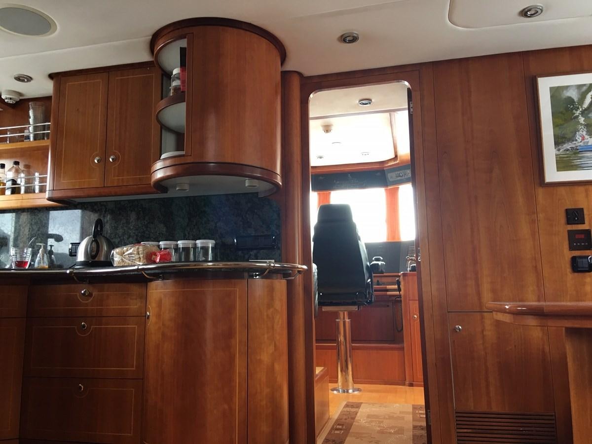 a kitchen with wooden cabinets aboard MAVERICK Yacht for Sale