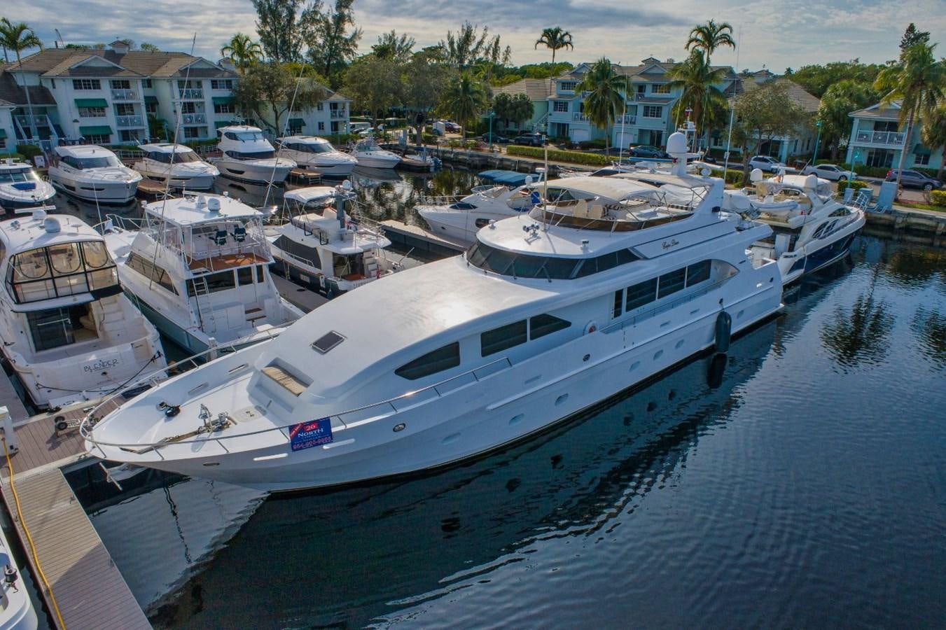 a large white boat in a harbor aboard CARPE DIEM Yacht for Sale