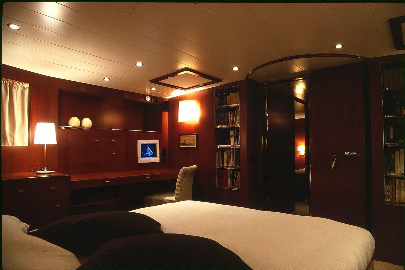 a room with a bed and a book shelf aboard FREE AT LAST Yacht for Sale
