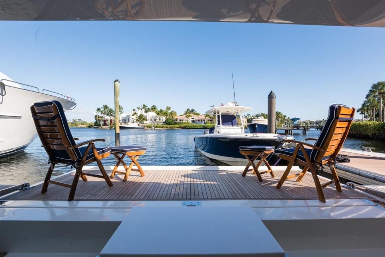 a deck with chairs and a boat on it aboard TOMORROW WE RIDE Yacht for Sale