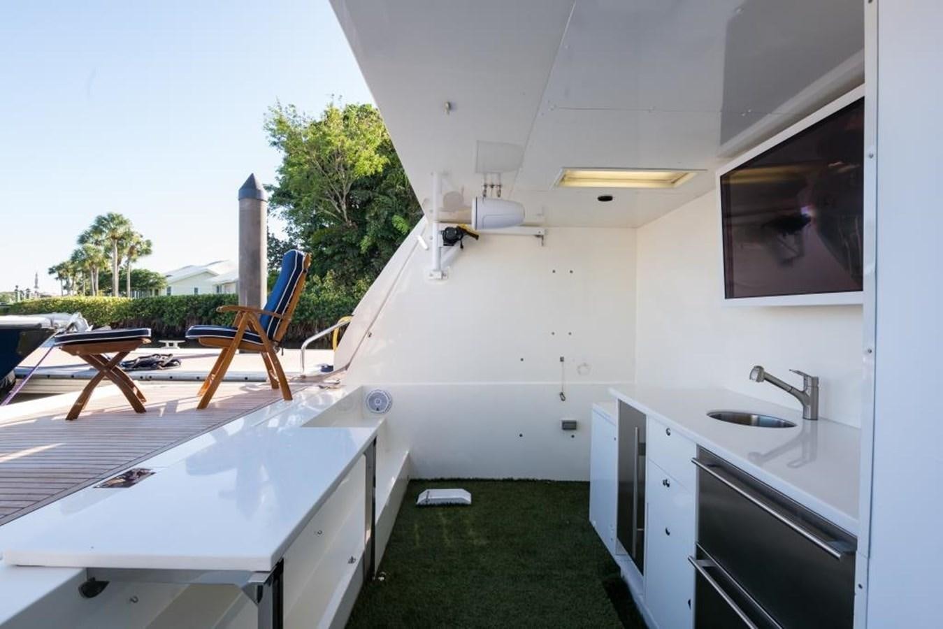 a small white kitchen with a sink and a barbecue grill aboard TOMORROW WE RIDE Yacht for Sale
