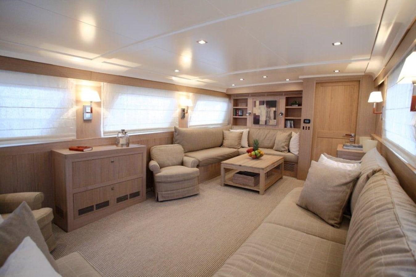 a living room with a couch and a coffee table aboard CONQUEST OF 1966 Yacht for Sale