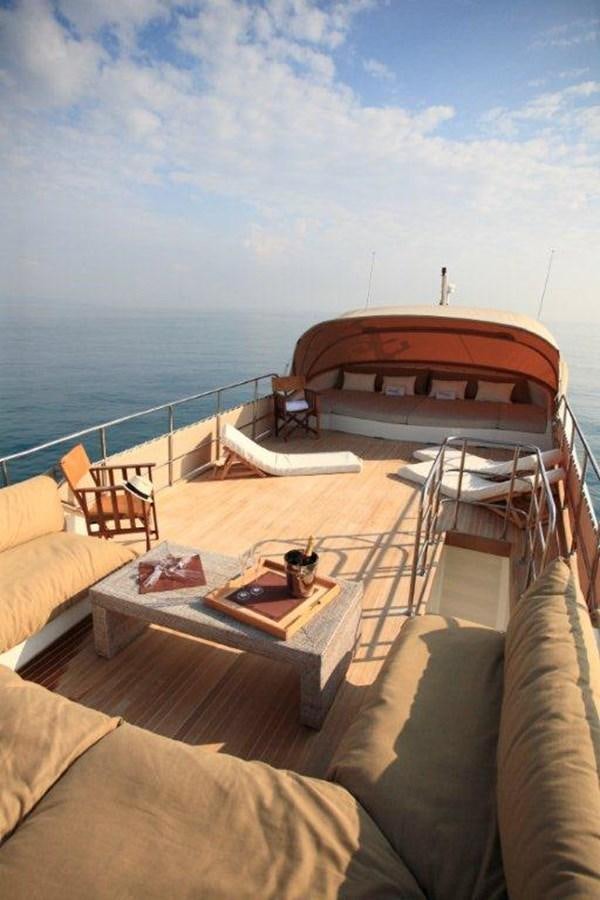 a balcony with a table and chairs on it aboard CONQUEST OF 1966 Yacht for Sale