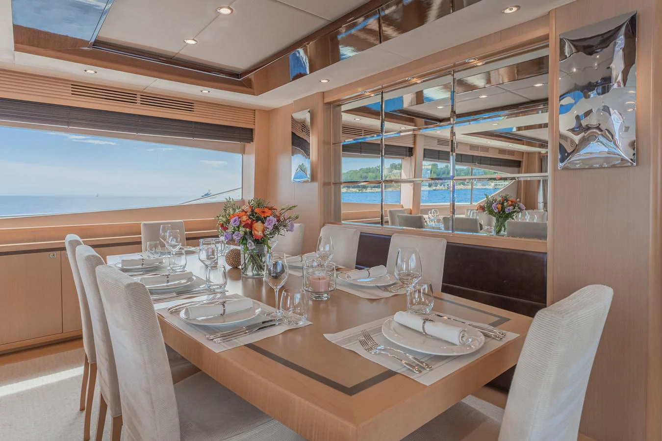 a dining table with white plates and glasses on it aboard BLUE EYES Yacht for Sale