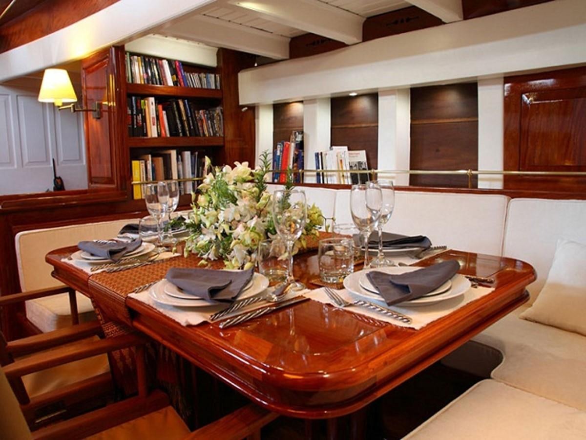 a table with plates and glasses on it aboard AVENTURE Yacht for Sale
