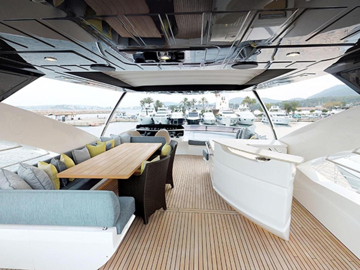 a boat deck with a table and chairs aboard SKI Yacht for Sale