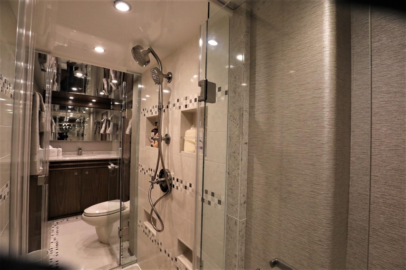 a bathroom with a glass shower aboard 2022 VIKING 92 ENCLOSED SKYBRIDGE (TBD) Yacht for Sale
