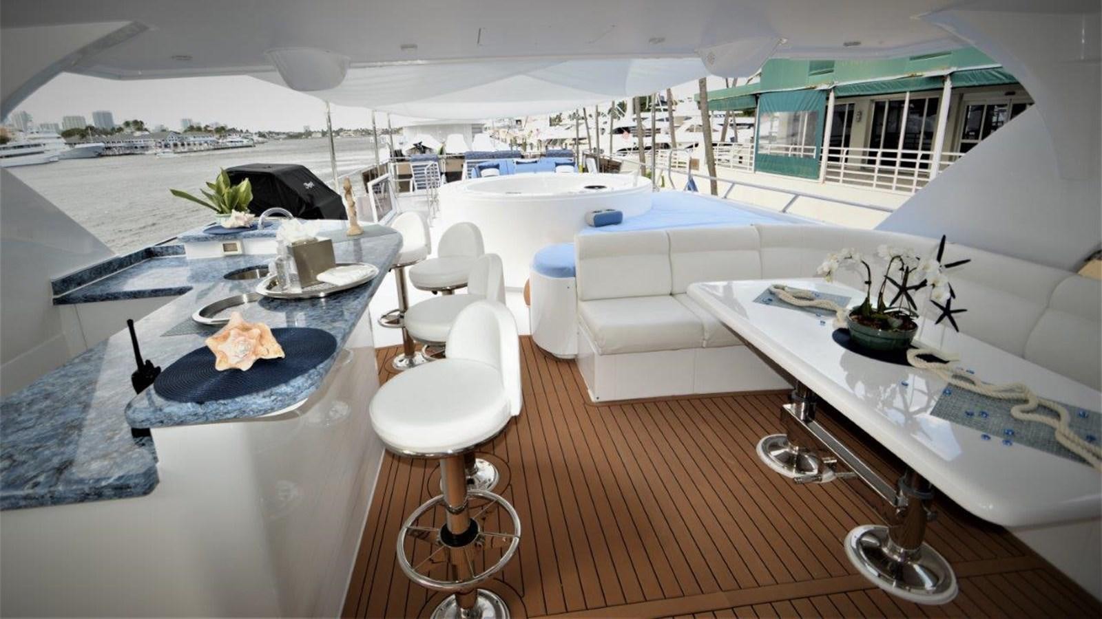 a room with a table chairs and a large white building with a view of the city aboard TRIPLE NET Yacht for Sale