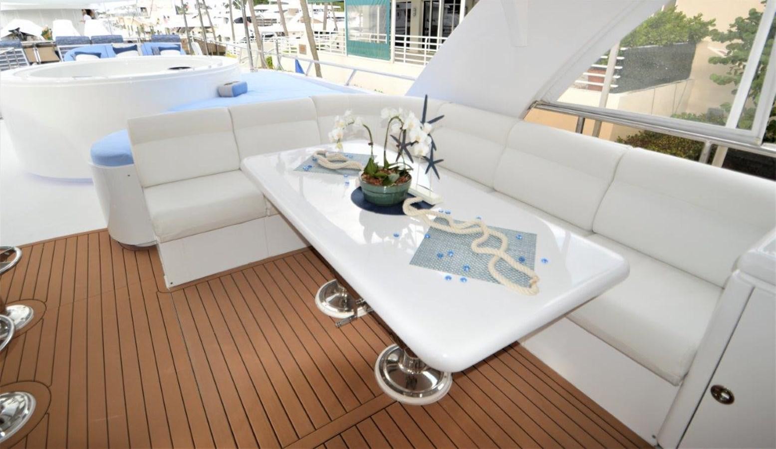 a white couch with a table and chairs on it aboard TRIPLE NET Yacht for Sale