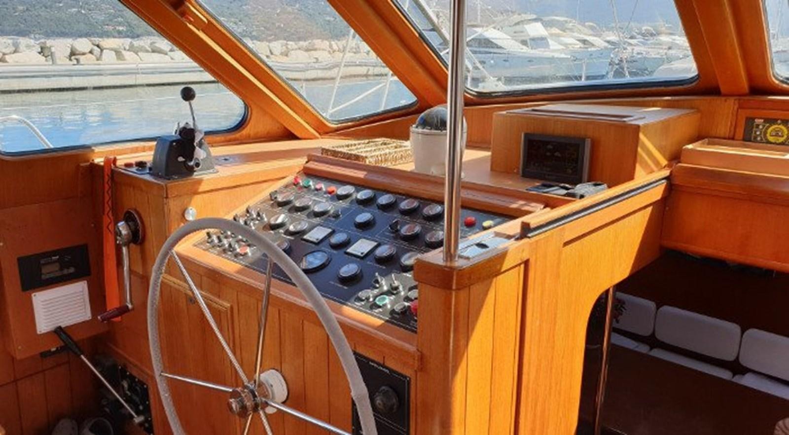 a wooden boat with a large wooden boat in the water aboard ACOA Yacht for Sale