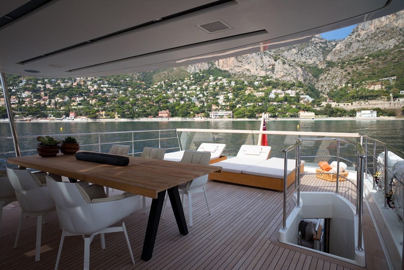 a table and chairs on a balcony overlooking a city aboard ELMO Yacht for Sale