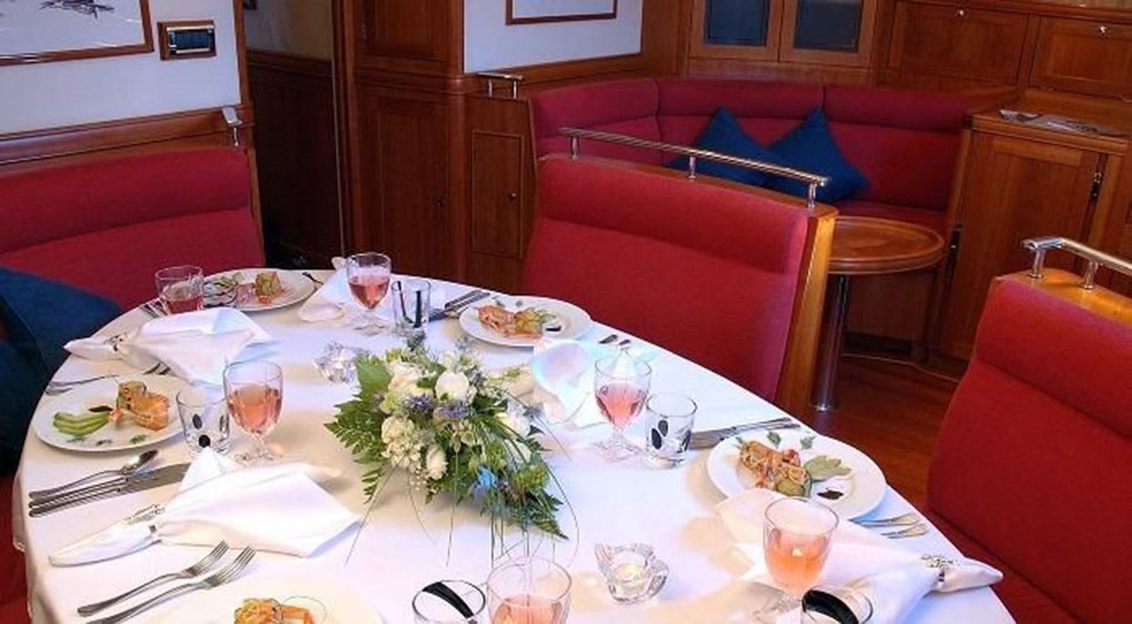 a table with plates and glasses on it aboard DARK STAR OF LONDON Yacht for Sale
