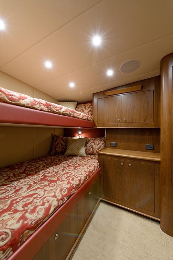 a bedroom with a bed and a dresser aboard BANGARANG Yacht for Sale