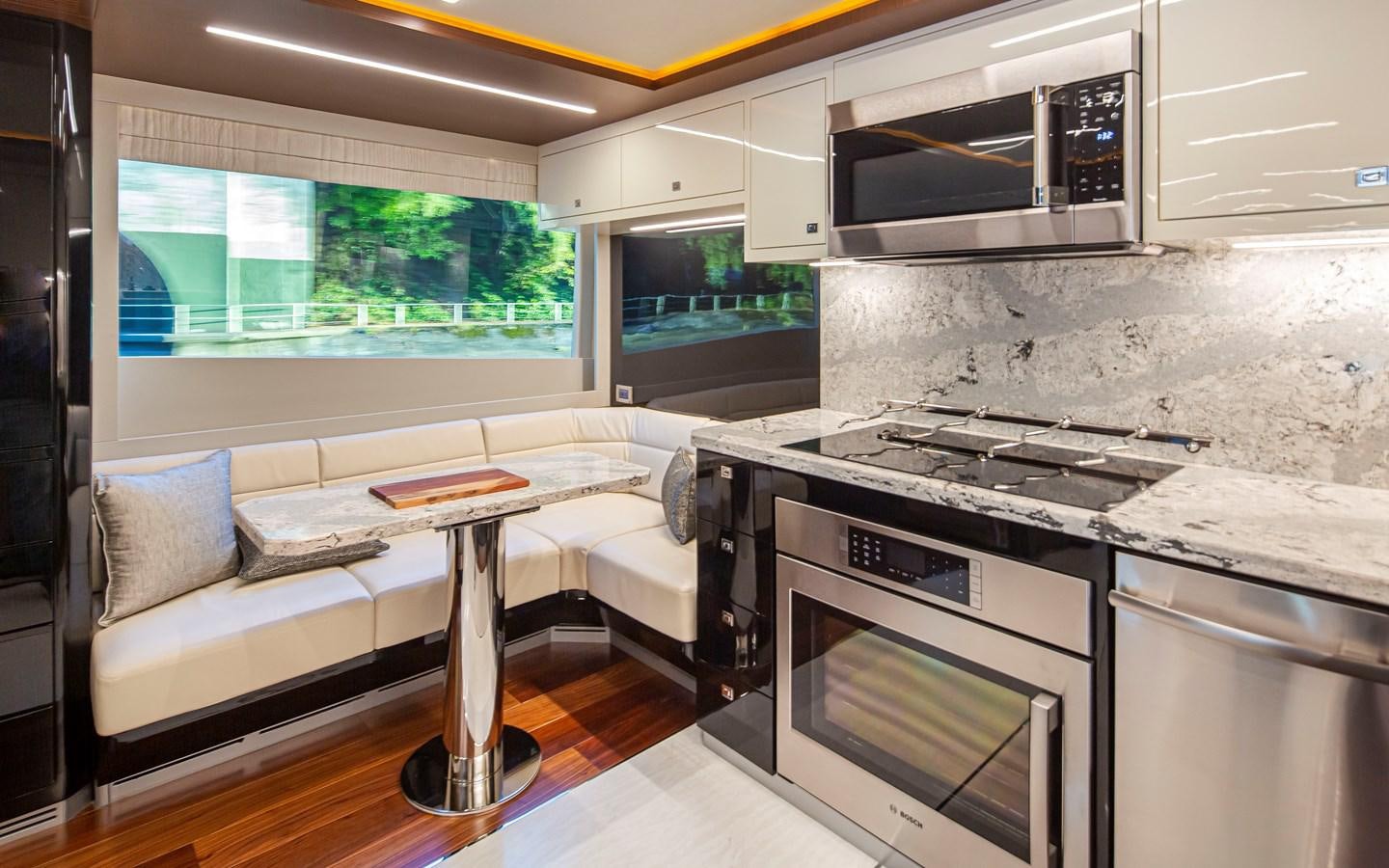 a kitchen with a table and a couch aboard 90R03 Yacht for Sale