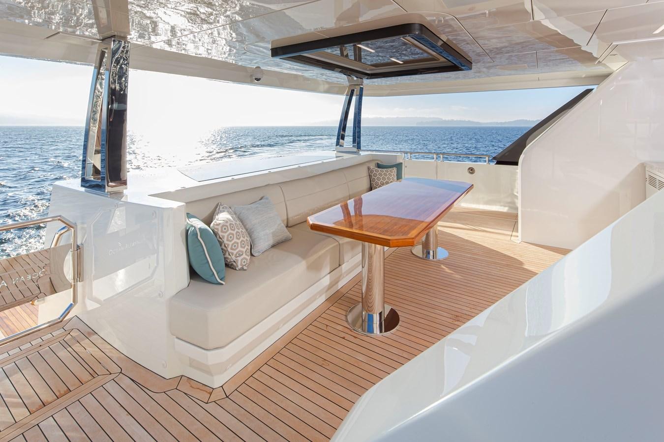 a balcony with a table and chairs aboard 90R03 Yacht for Sale