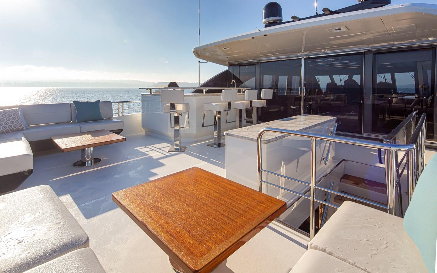 a deck with a table and chairs aboard 90R03 Yacht for Sale