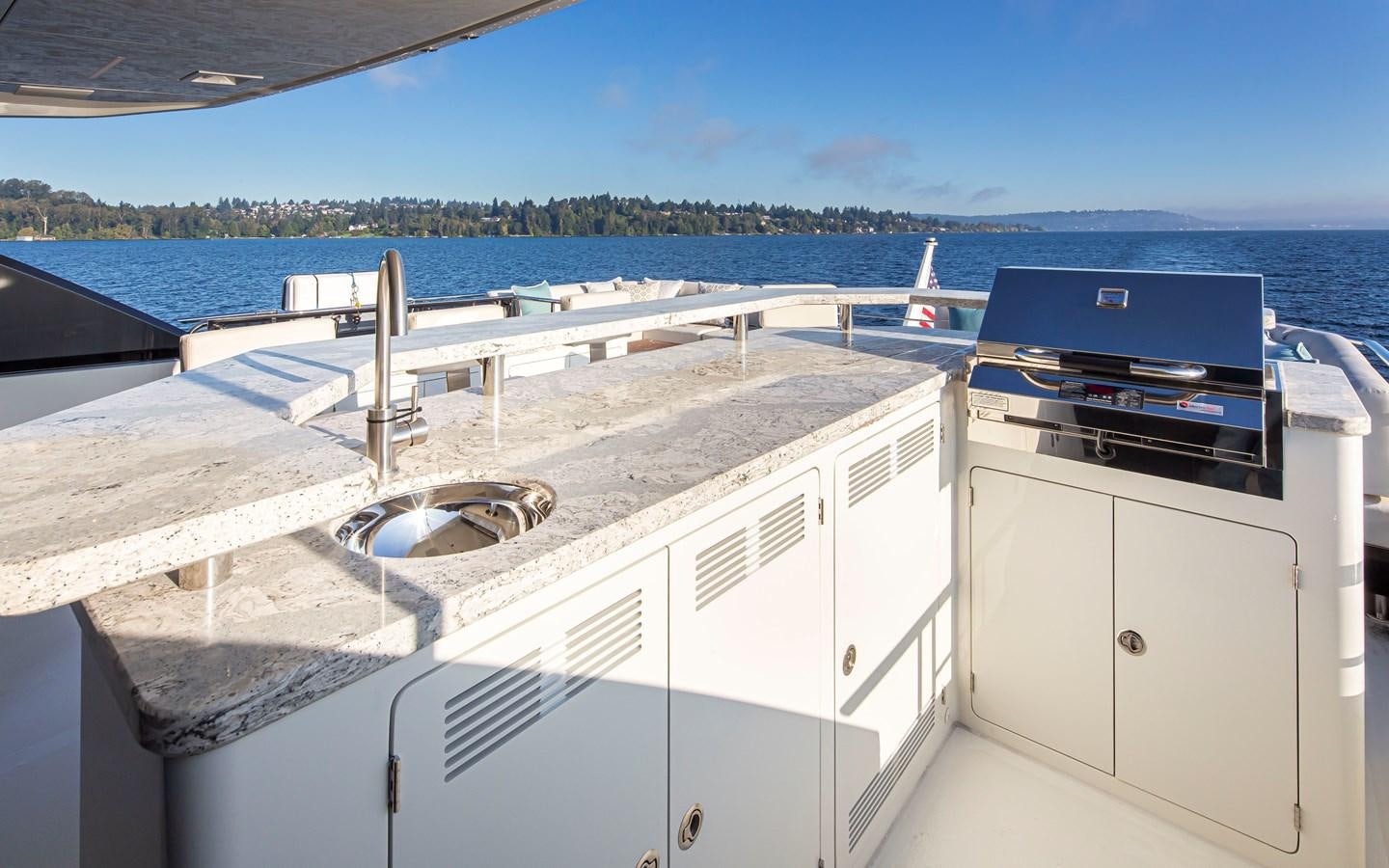 a large white kitchen with a view of the water and a city aboard 90R03 Yacht for Sale