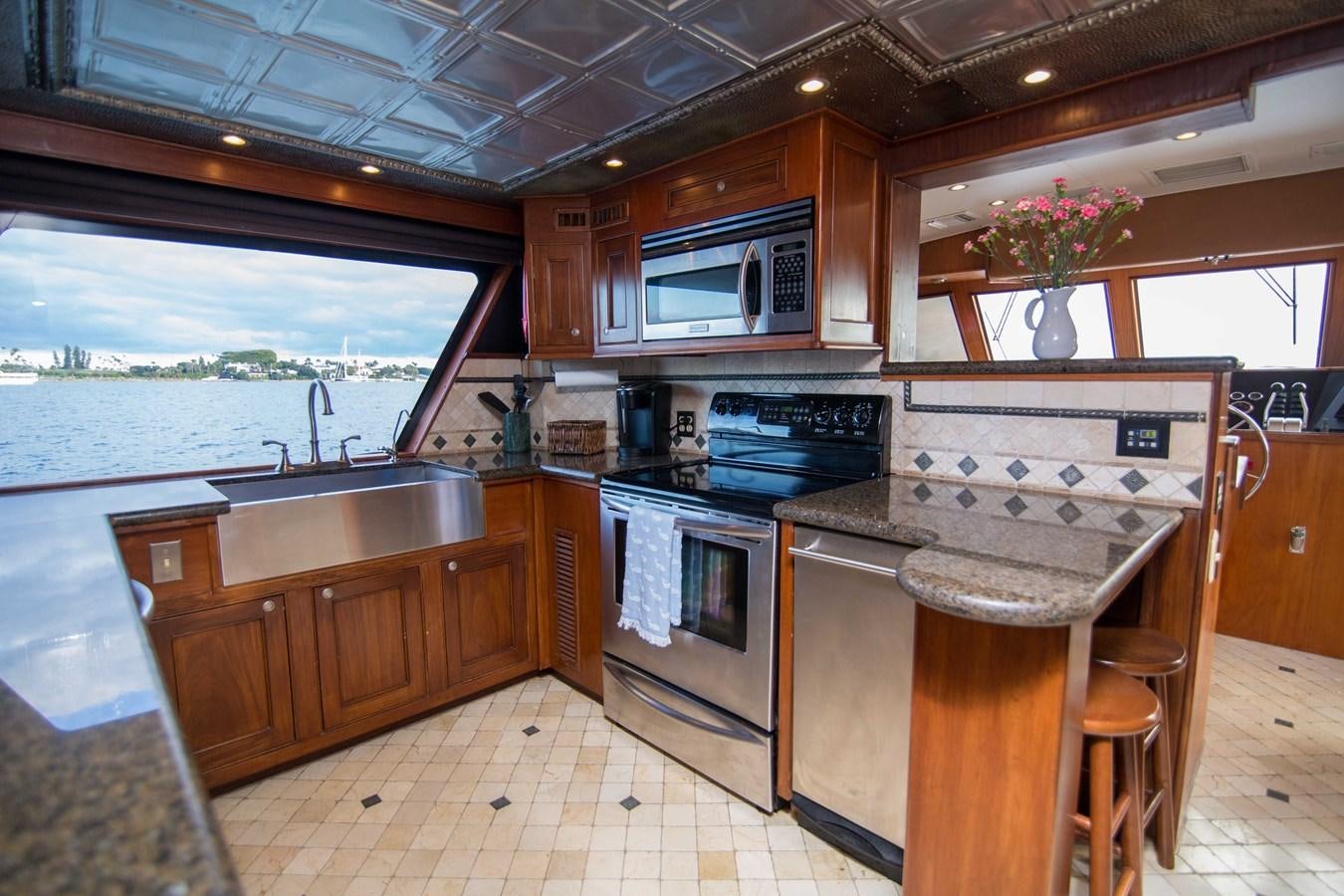 a kitchen with wooden cabinets aboard NEXT DEAL Yacht for Sale