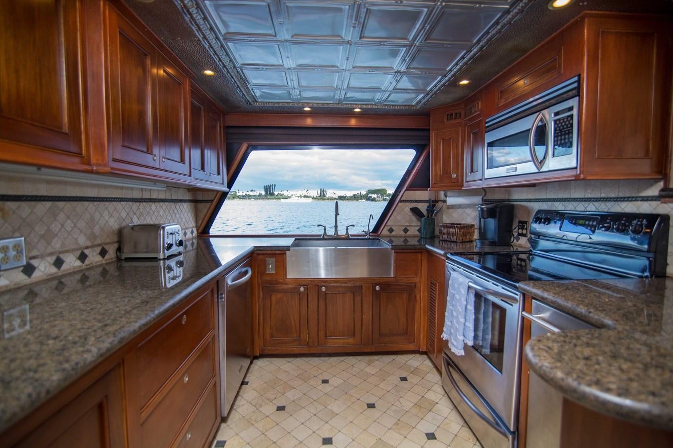 a kitchen with wooden cabinets aboard NEXT DEAL Yacht for Sale
