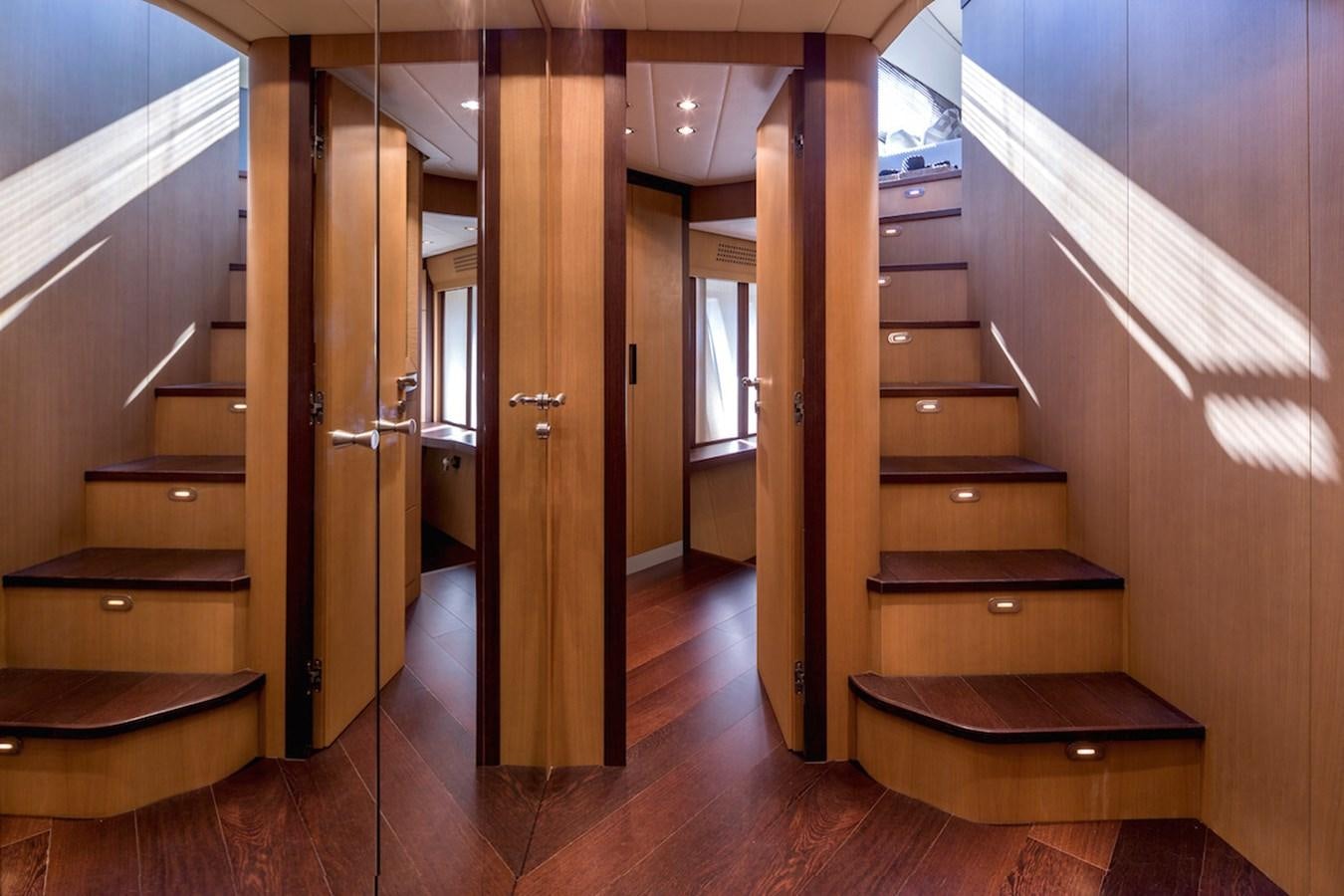 a room with wooden floors and a wood staircase aboard ONE Yacht for Sale