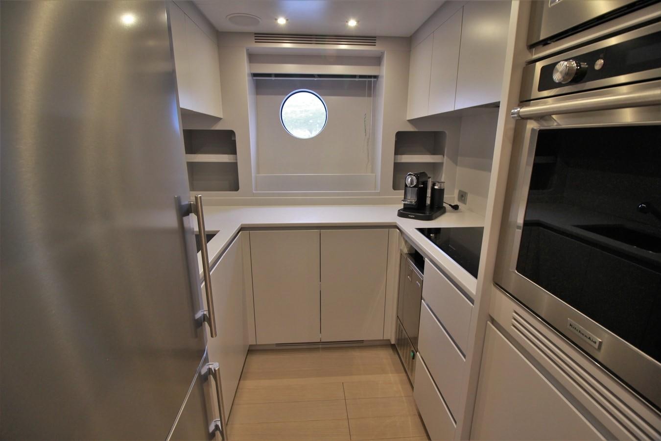 a kitchen with white cabinets aboard VERSILCRAFT V86 Yacht for Sale