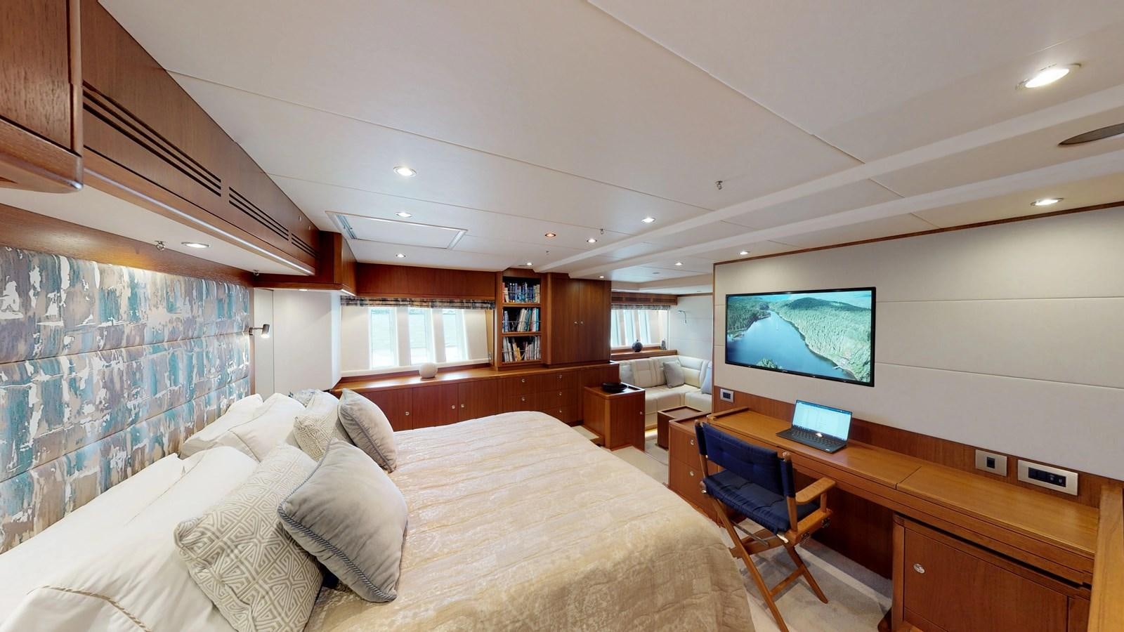 a bedroom with a bed and a desk aboard AYNI Yacht for Sale