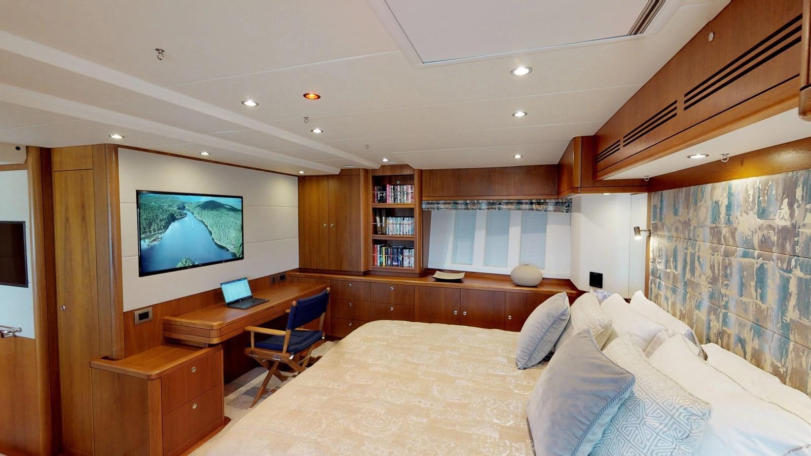 a bedroom with a bed and a desk aboard AYNI Yacht for Sale