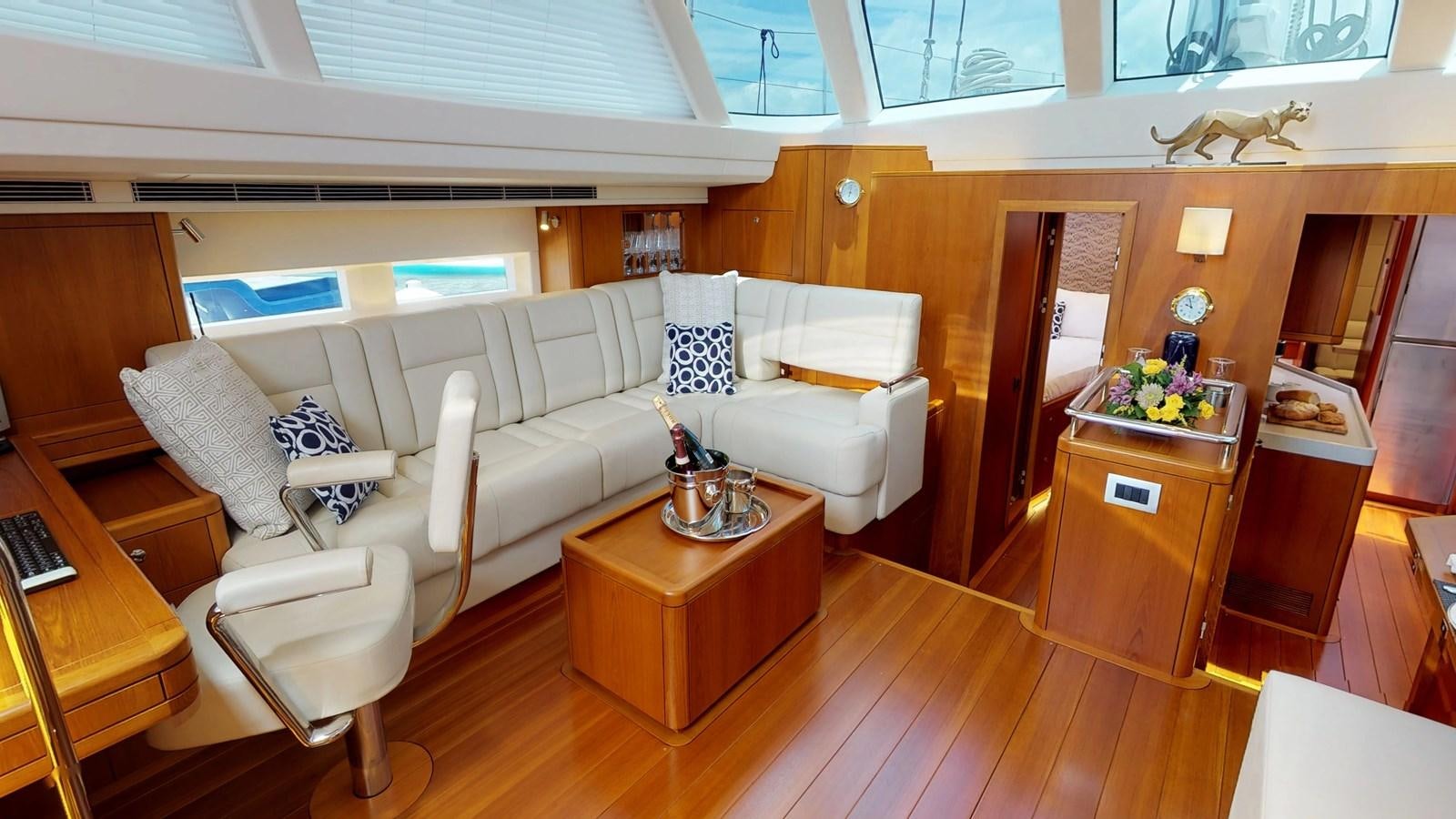 a living room with a couch and a coffee table aboard AYNI Yacht for Sale
