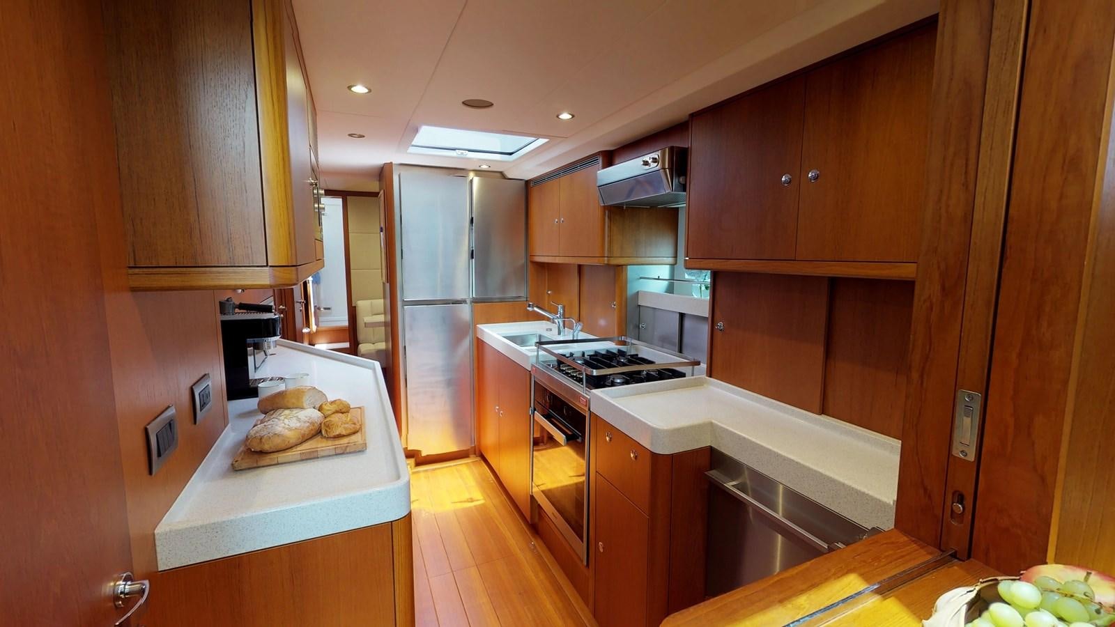 a kitchen with wooden cabinets aboard AYNI Yacht for Sale