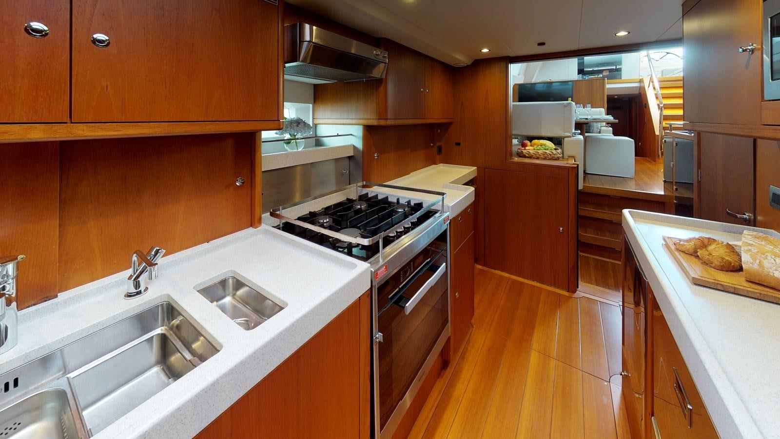 a kitchen with wooden cabinets aboard AYNI Yacht for Sale
