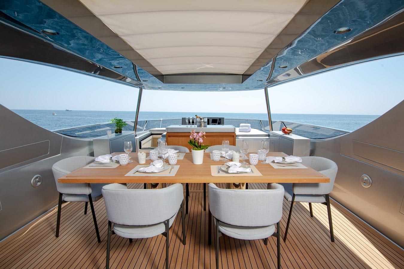 a table with chairs and a large umbrella aboard CANADOS 888 EVO Yacht for Sale