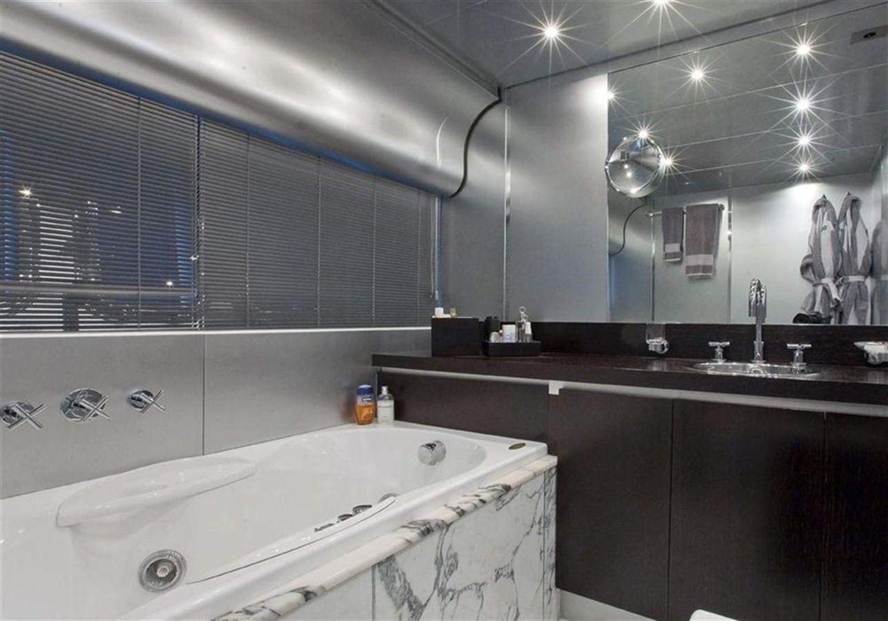 a bathroom with a bathtub and sinks aboard ZAMBOANGA Yacht for Sale