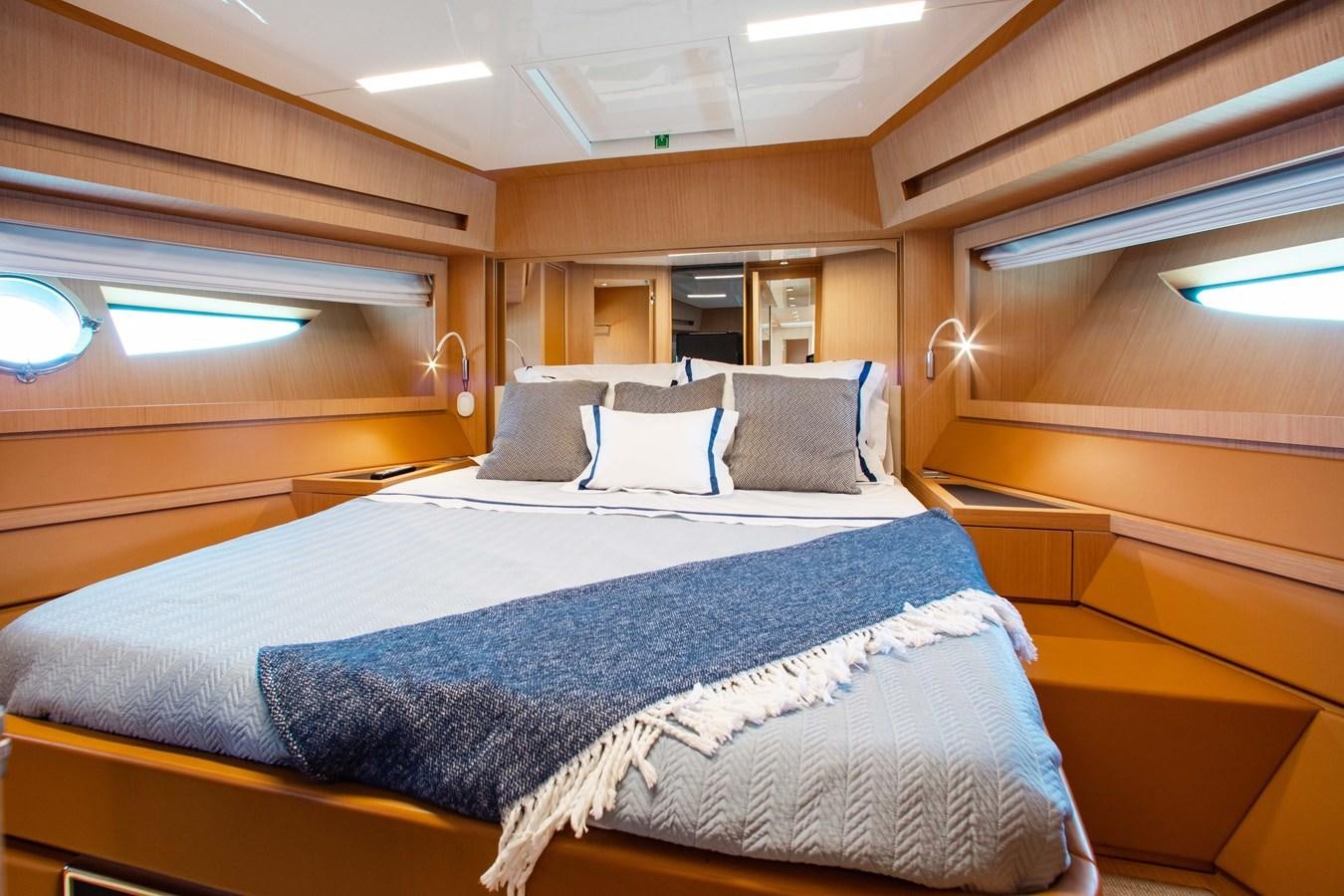 a bed with blue sheets aboard AMARA  Yacht for Sale