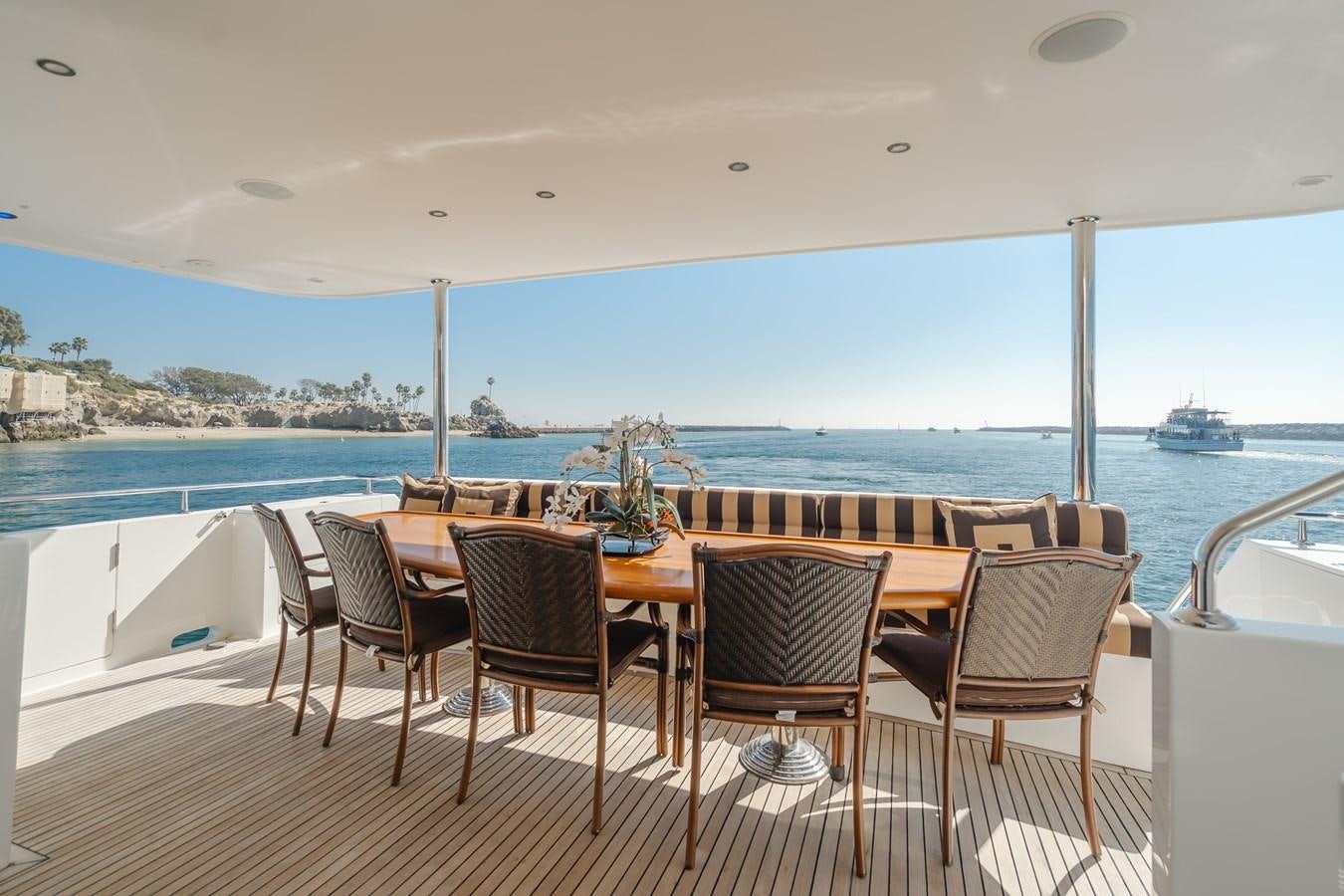 a table and chairs on a deck overlooking a body of water aboard HAWK EYE  Yacht for Sale