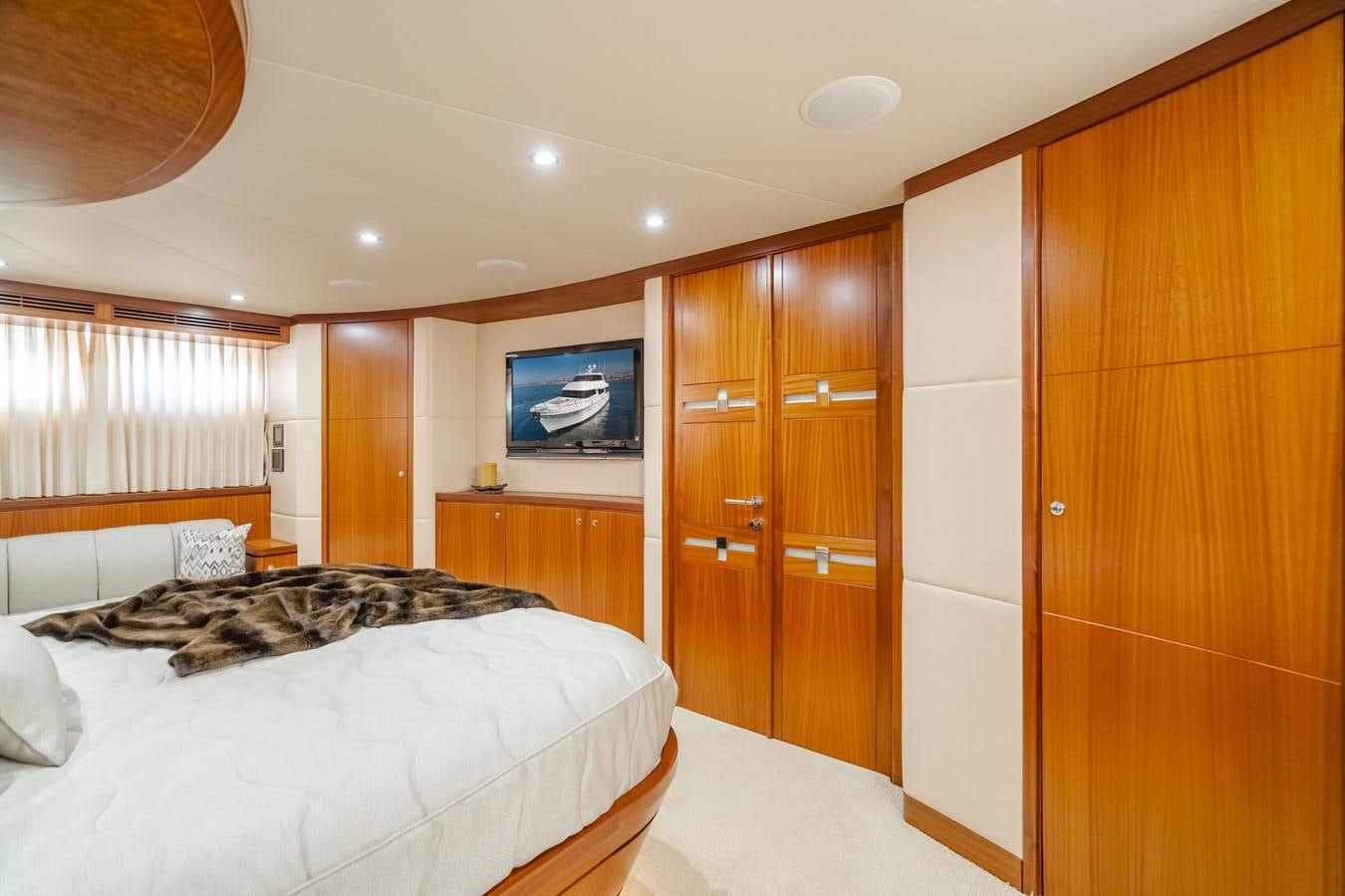 a bedroom with a bed and a tv on the wall aboard HAWK EYE  Yacht for Sale