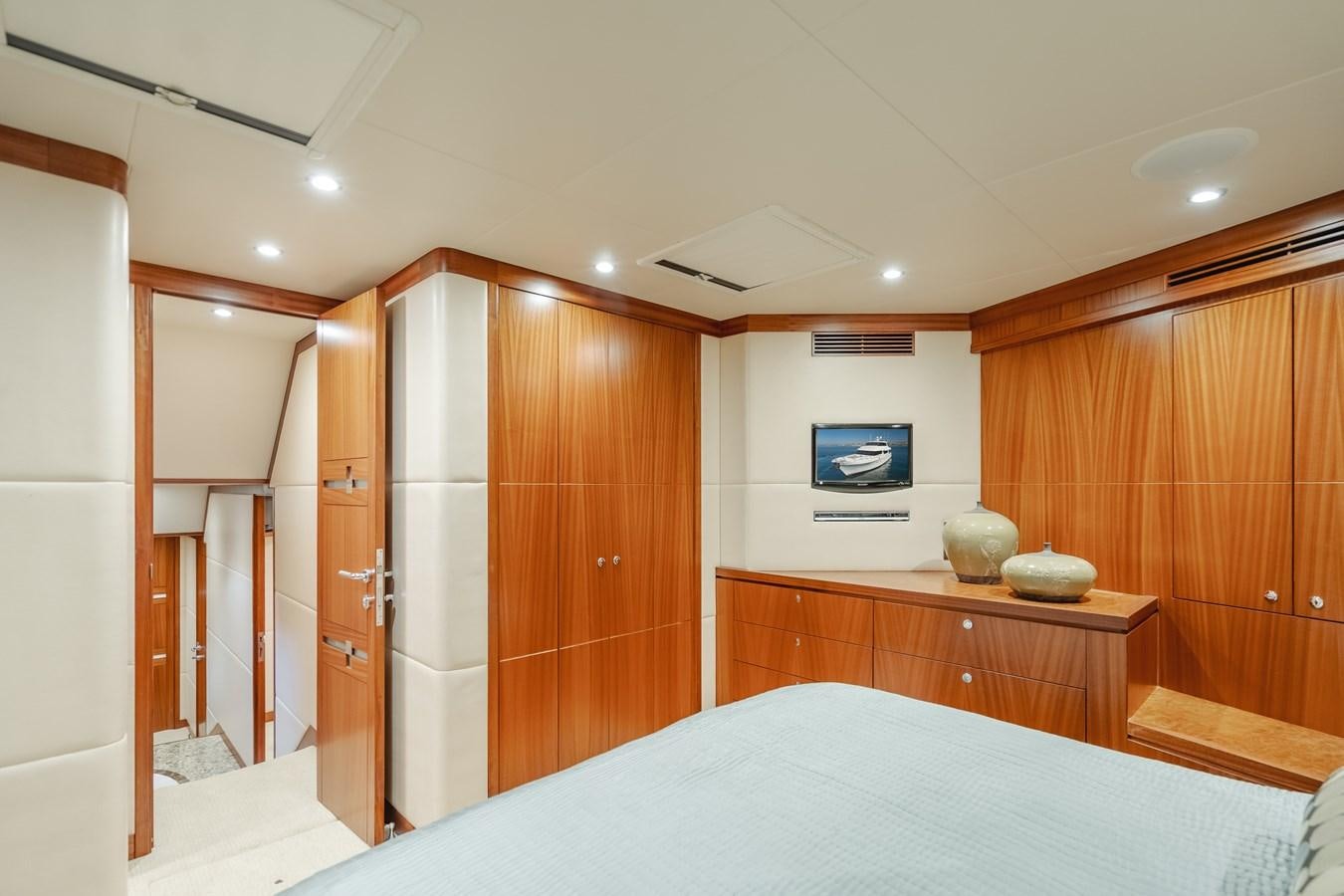a bedroom with a bed and a wood cabinet aboard HAWK EYE  Yacht for Sale