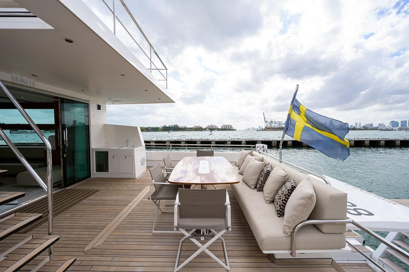 a deck with a couch and a table and chairs on it aboard CHREEDO Yacht for Sale