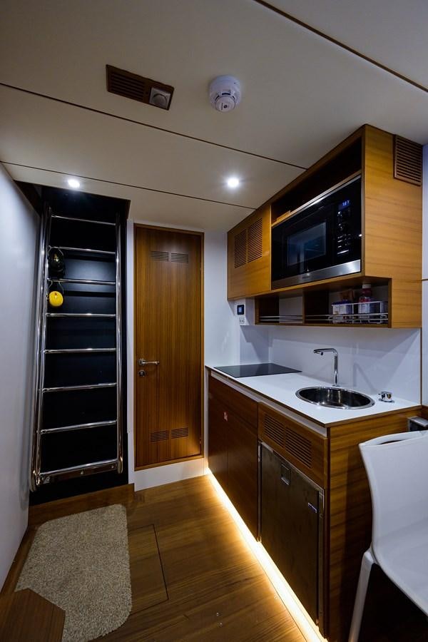 a kitchen with a black refrigerator aboard CHREEDO Yacht for Sale