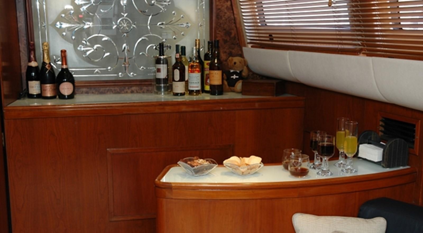 a bar with a variety of bottles and glasses on it aboard SOUTHERN CROSS Yacht for Sale