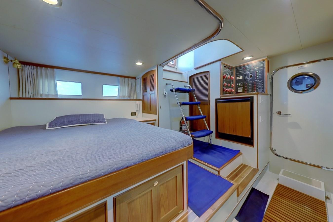 a bedroom with a bed and a television aboard ONE LIFE Yacht for Sale